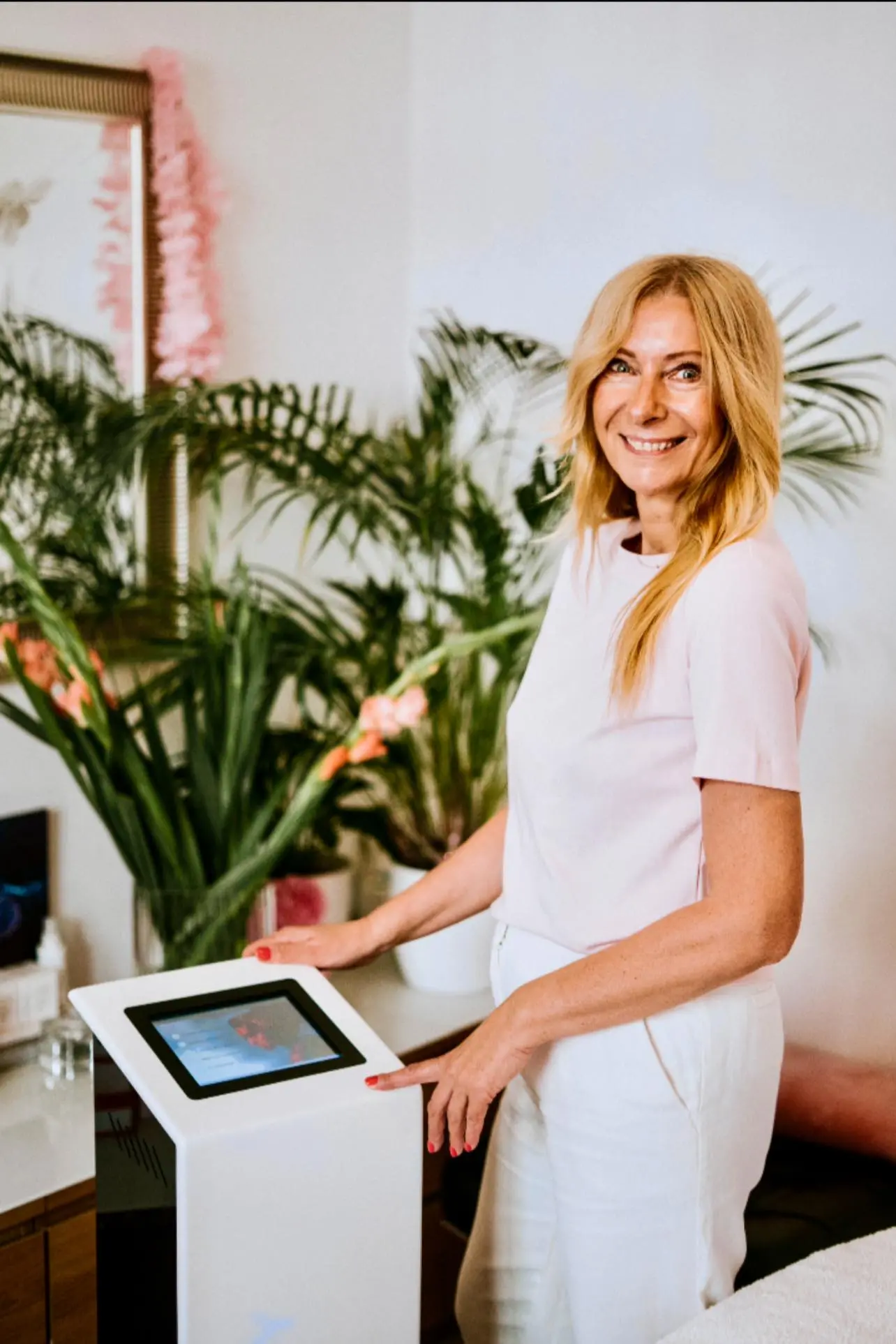 Izabela Loranc w salonie Beauty Skin Bielsko-Biała – kosmetolożka przy nowoczesnym urządzeniu do zabiegów, jasne wnętrze z roślinami